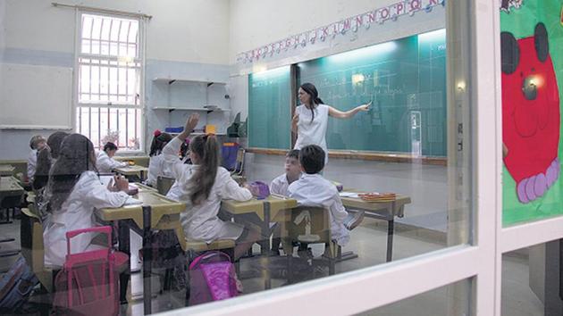 maestra de primaria en clase, con chicxs de primaria. en aula.