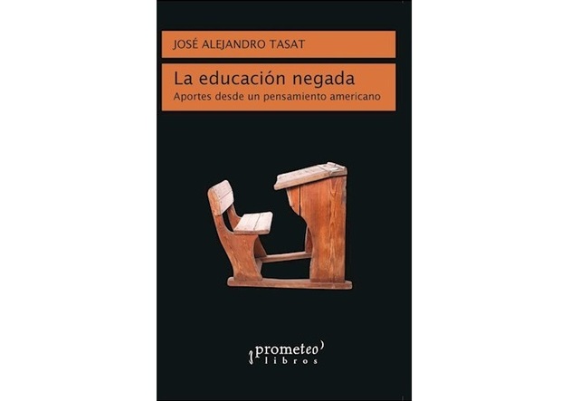 Tapa del libro La educación negada. Fondo negro y un pupitre de madera antiguo.