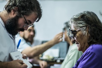 Primer plano toma entre paciente y optómetro trabajando en prueba anteojos