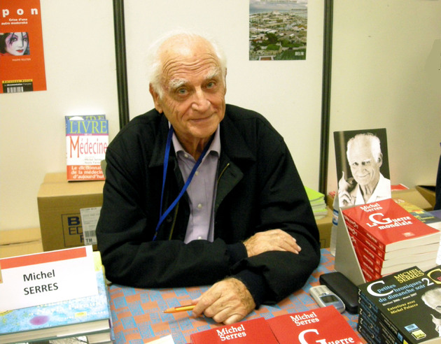 Se ve a Michel Serres sentado en una firma de autógrafos de sus libros
