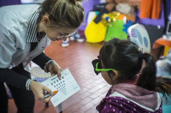 optómetra haciendo control visual a una niña