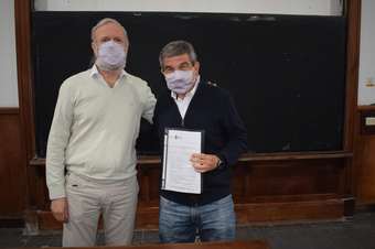 Mauricio Erben (izquierda) con Roberto Salvarezza (derecha) muestran el documento entregado